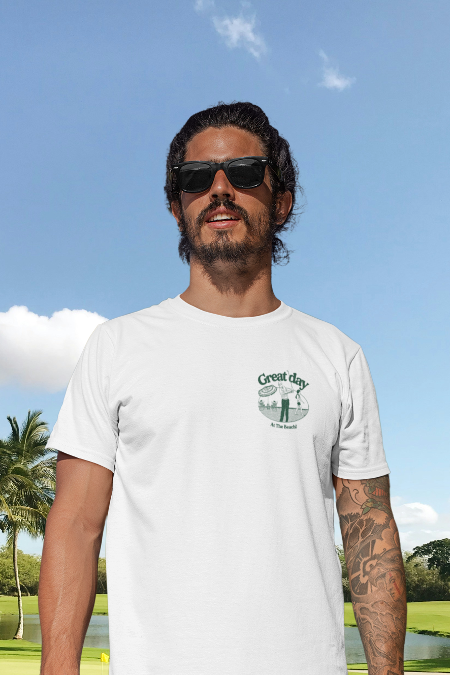 Man wearing a white t-shirt and colorful shorts standing on a golf course.